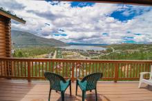 Two chairs on a wooden patio overlooking Grand Lake.